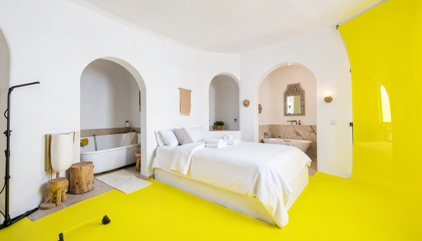 Grande suite d'inspiration mauresque, murs blancs, lit double et coin salon en alcôve, grande salle de bain avec baignoire, surplombant le bief